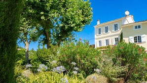 Una casa tradizionale a due piani con un giardino antistante.