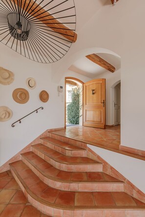 Eine Treppe mit Terrakottafliesen, die zu einer Holztür führt.