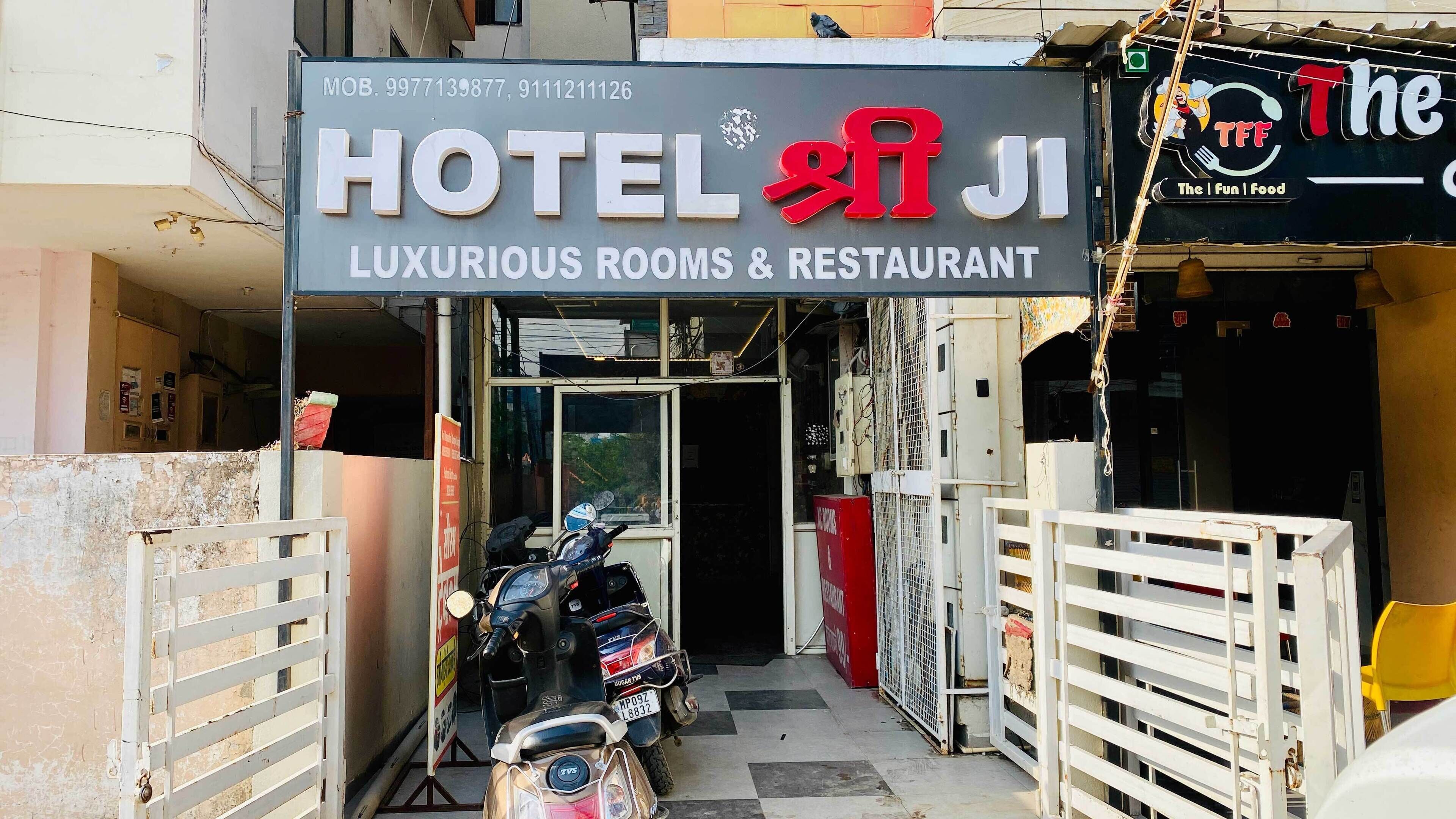 A hotel entrance with a sign indicating "HOTEL J1 LUXURIOUS ROOMS & RESTAURANT."