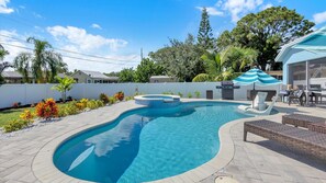 A swimming pool with a hot tub, surrounded by a patio area with outdoor furniture. - Gem of Jensen Beach (Jensen Beach)
