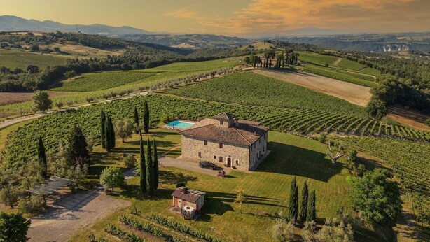 A stone villa surrounded by vineyards, with a swimming pool and a small guesthouse.