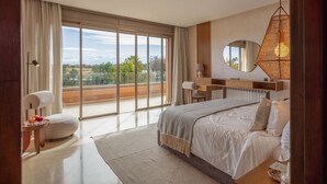 Een moderne slaapkamer met een groot bed, een bureau en uitzicht op het omliggende landschap.
