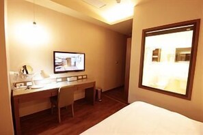 A hotel room with a bed, a desk, a chair, a television, and a window. - Kindness Hotel Qixian Kaohsiung (Kaohsiung)