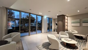 A modern living room with a large sliding glass door leading to an outdoor area, furnished with sofas and a coffee table. - GOGOTO Burj & Fountain View Stay (Dubai)