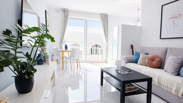 Una sala de estar moderna con sofá, mesa de centro y plantas en macetas.