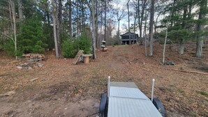 A forested area with a dirt path leading to a cabin. -  Newly listed: Ray's Retreat  (Webster)