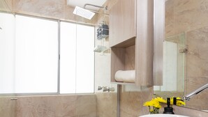 A modern bathroom with a shower, toilet, and sink.