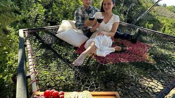 Couples can enjoy a romantic picnic in a serene outdoor setting, surrounded by lush greenery.