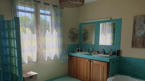 Une salle de bain avec deux lavabos, une grande baignoire, des meubles en bois et un miroir au-dessus du lavabo.
