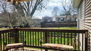 A wooden deck with two cushioned chairs and a pergola overhead. - Charming 3-bedroom house in  wonderful and fascinating Berlin, MD. (Berlin)
