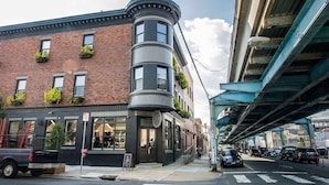 A corner building with a brick facade, large windows, and a curved section. - Historic Old City 1 Bedroom, 1 Bath (Philadelphia)