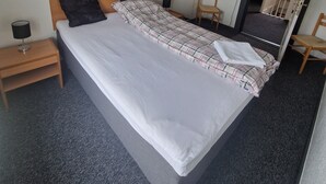 A hotel room with a large bed, a nightstand, a chair, a desk, and a mirror. - Knudstrup Kro & Hotel (Kjellerup)