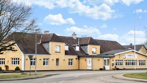 A yellow building with a sign reading "Kindstrup". - Knudstrup Kro & Hotel (Kjellerup)