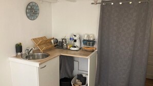 A compact kitchen with a sink, a coffee maker, and a small storage area. - Independent Cozy Room (Montpellier)