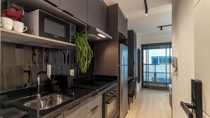 A modern kitchen with a stainless steel sink, a microwave, and a built-in oven. - 360 Oscar Itaim (São Paulo)