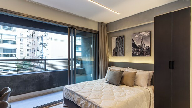 A modern bedroom with a large bed, a sliding glass door to a balcony, and artwork on the wall. - 360 Oscar Itaim (São Paulo)