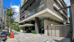 A modern building with a covered entrance, a parking area, and a gated section. - 360 Oscar Itaim (São Paulo)