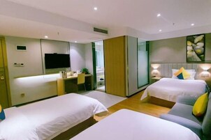 Habitación de hotel con dos camas, un escritorio, un televisor y un baño.