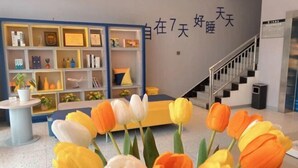 Un interior moderno con una escalera, una estantería y una pared con caracteres chinos.