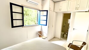 Une chambre à coucher avec un lit, une chaise et une armoire.