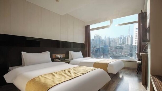 A hotel room with two beds, a city view, and a large window. - Durian Candy Hotel (Longhua Road Subway Station Jiangpu Bus Terminal Branch) (Nanjing)