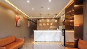 A reception area with a marble counter, leather sofas, and wall-mounted artwork. - Durian Candy Hotel (Longhua Road Subway Station Jiangpu Bus Terminal Branch) (Nanjing)