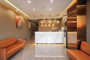 A hotel reception area with a marble counter, leather seating, and wall-mounted decor. - Durian Candy Hotel (Longhua Road Subway Station Jiangpu Bus Terminal Branch) (Nanjing)