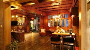 A cozy restaurant with wooden interiors, a bar area, and a seating arrangement for guests. - Dengnilai Inn (Fenghuang County)