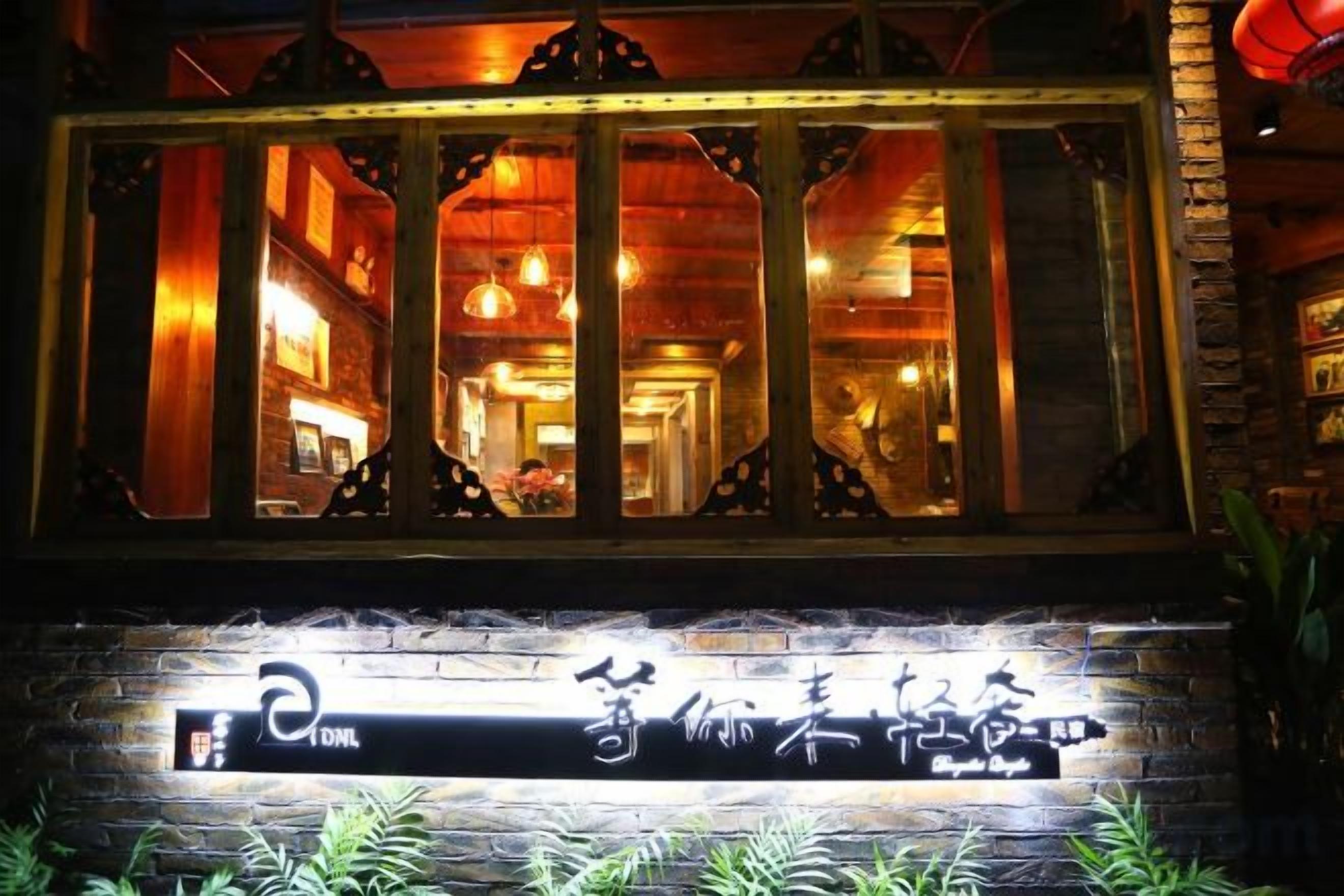 Restaurante com estilo arquitetônico asiático tradicional, apresentando fachada de madeira e placa com caracteres chineses.