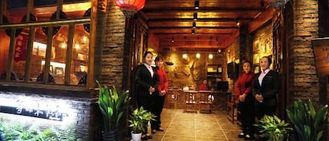 A traditional Chinese restaurant with wooden architecture, red lanterns, and potted plants.