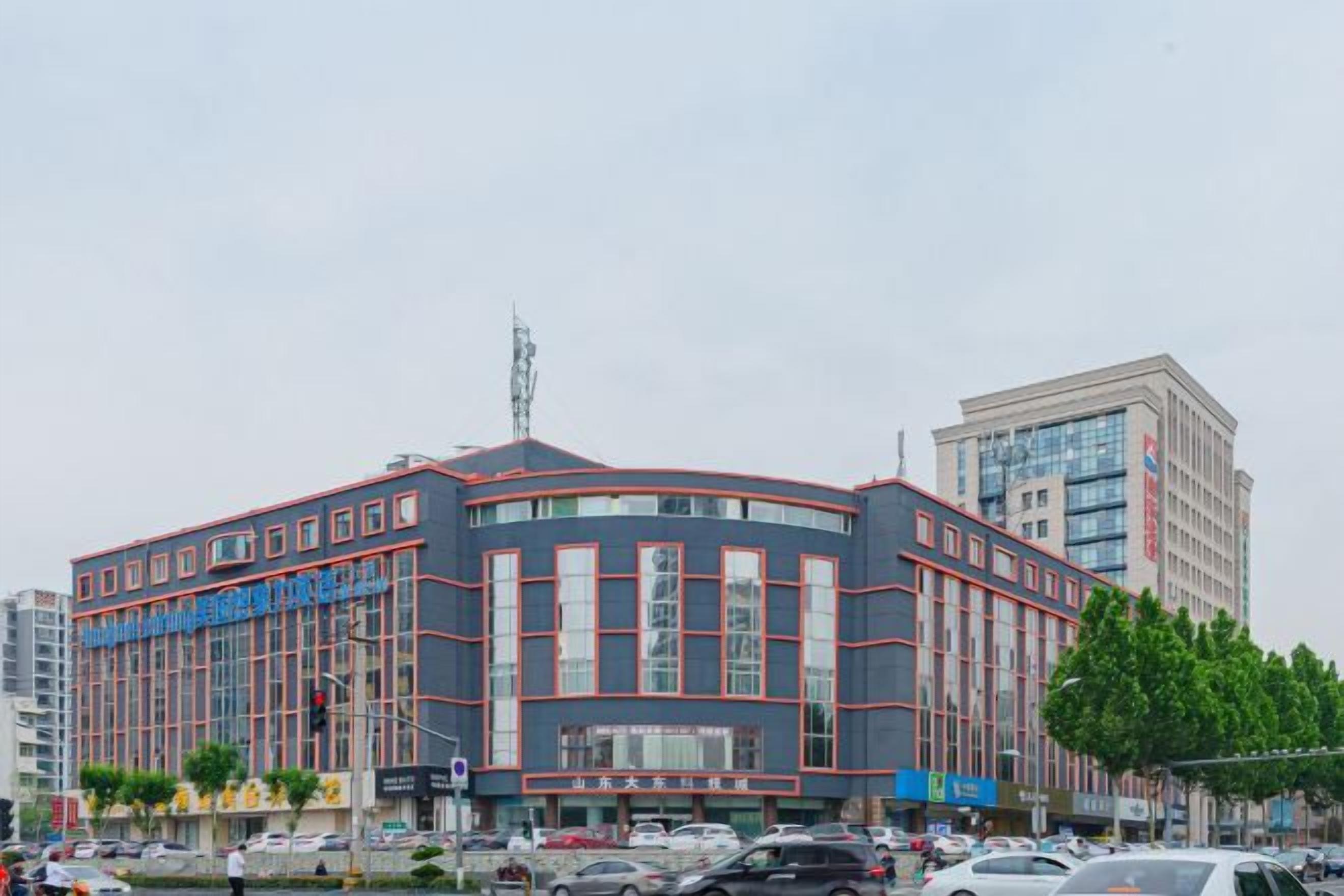 Un immeuble à plusieurs étages, doté d’une façade incurvée, de grandes fenêtres et d’une entrée imposante.