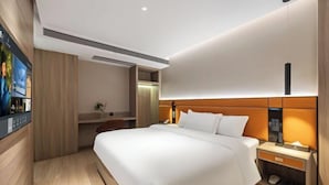 A modern hotel room with a large bed, a bedside table, a TV, and a built-in wardrobe. - Elong Anyun Hotel (Nantong Haohe Scenic Area Zhongxiu West Road Subway Station) (Nantong)