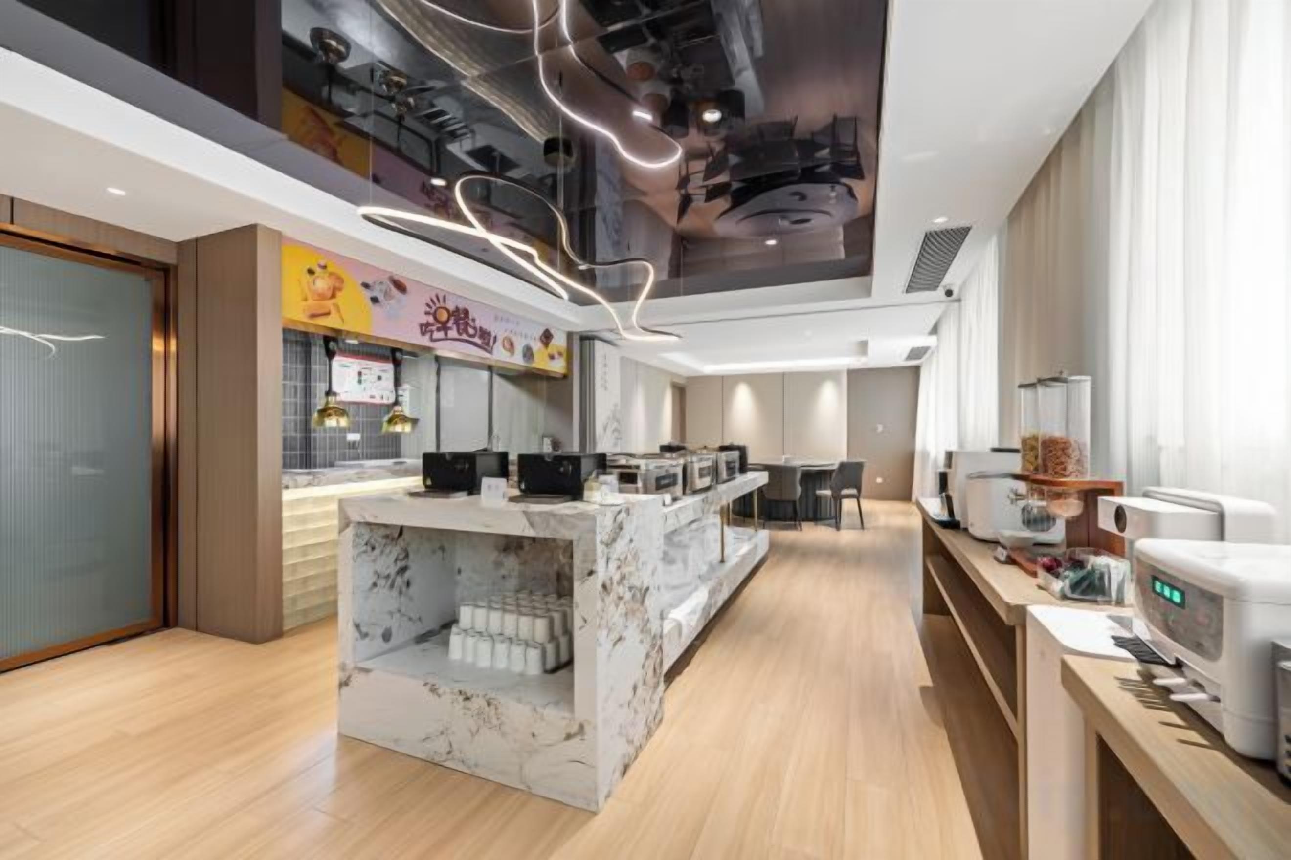 A modern kitchen with marble countertops, a coffee station, and a dining area.