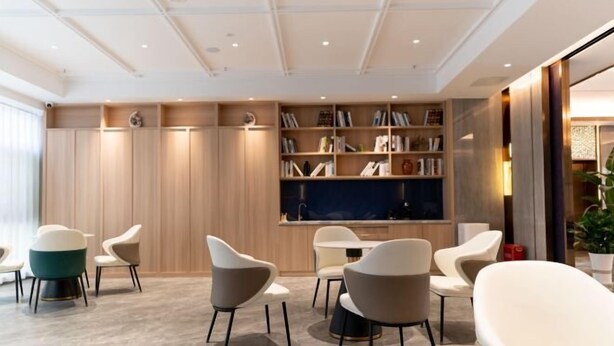A modern interior with a bookshelf, seating area, and a large flat-screen TV. - Elong Anyun Hotel (Nantong Haohe Scenic Area Zhongxiu West Road Subway Station) (Nantong)
