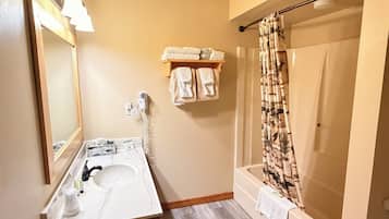 Deluxe Suite - 1 King Bed & Kitchenette | Bathroom | Combined shower/tub, hair dryer, soap, shampoo