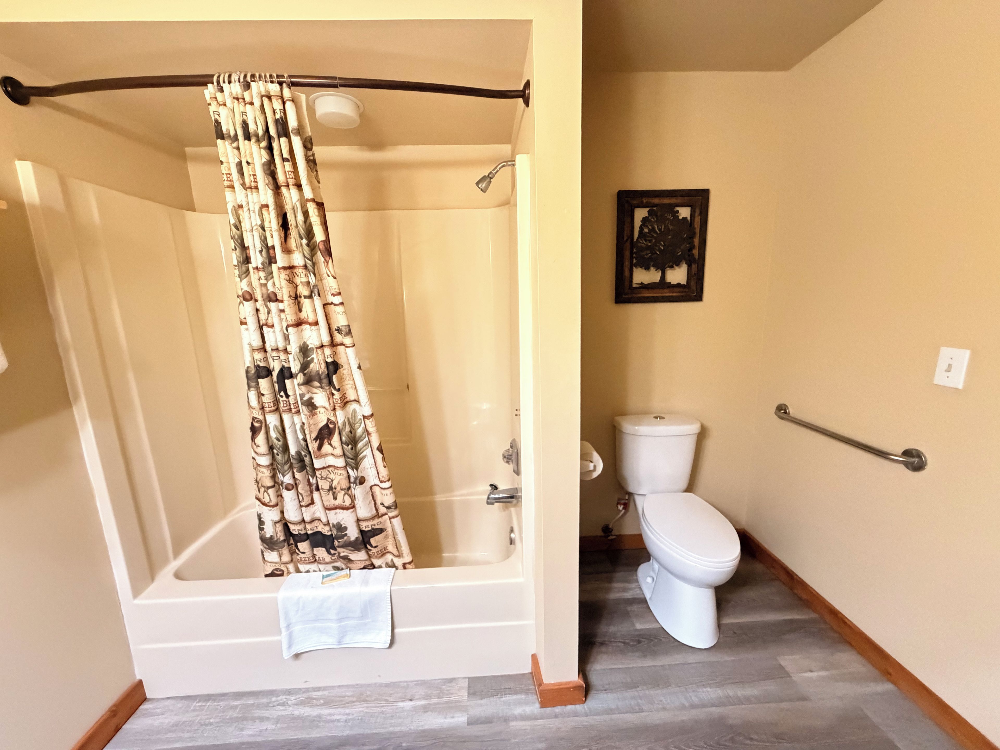 Un baño con bañera, inodoro, cortina de ducha y barra para toallas.