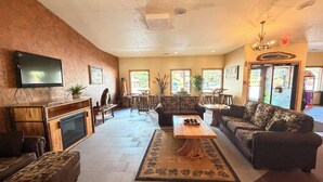 A spacious lobby with a fireplace, sofas, a coffee table, and a television. - Eagle River Inn and Resort  (Eagle River)