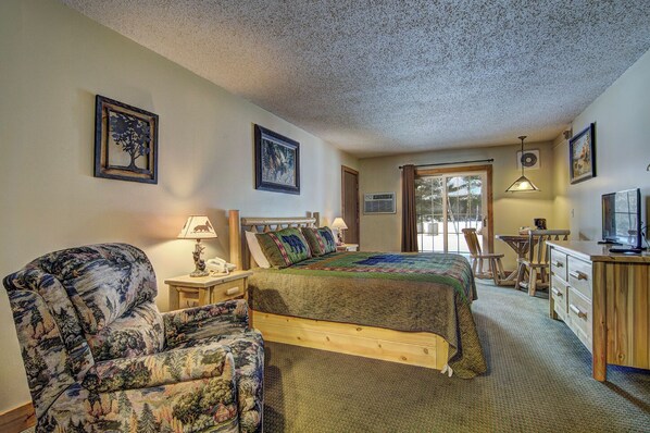 A cozy bedroom with a bed, a chair, a desk, and a television. - Eagle River Inn and Resort  (Eagle River)
