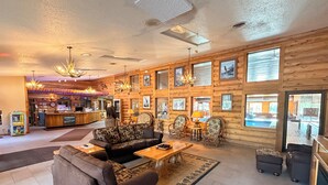 A spacious lobby with a reception desk, seating area, and a pool visible through the windows. - Eagle River Inn and Resort  (Eagle River)