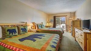 A hotel room with two beds, a desk, a chair, a television, and a sliding glass door leading to a balcony. - Eagle River Inn and Resort  (Eagle River)