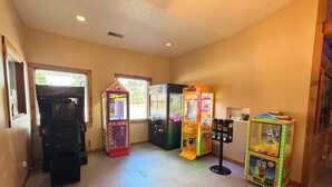 A room with arcade machines, a vending machine, and a small table with items. - Eagle River Inn and Resort  (Eagle River)