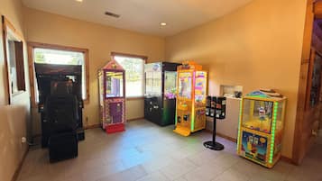 Una habitación con máquinas de arcade, una máquina expendedora y una pequeña mesa con objetos.