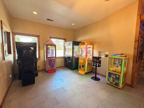 Ein Raum mit Spielautomaten, einer Verkaufsmaschine und einem kleinen Tisch mit Gegenständen.