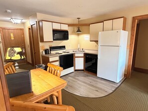 A compact kitchen with a stove, microwave, sink, and refrigerator. - Eagle River Inn and Resort  (Eagle River)