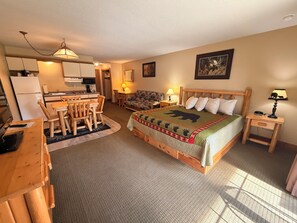 A cozy room with a bed, a dining table, chairs, a small kitchen area, and a television. - Eagle River Inn and Resort  (Eagle River)