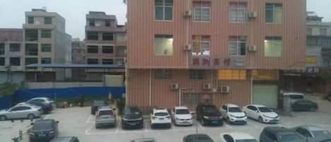 Un edificio de varios pisos con un estacionamiento al frente.