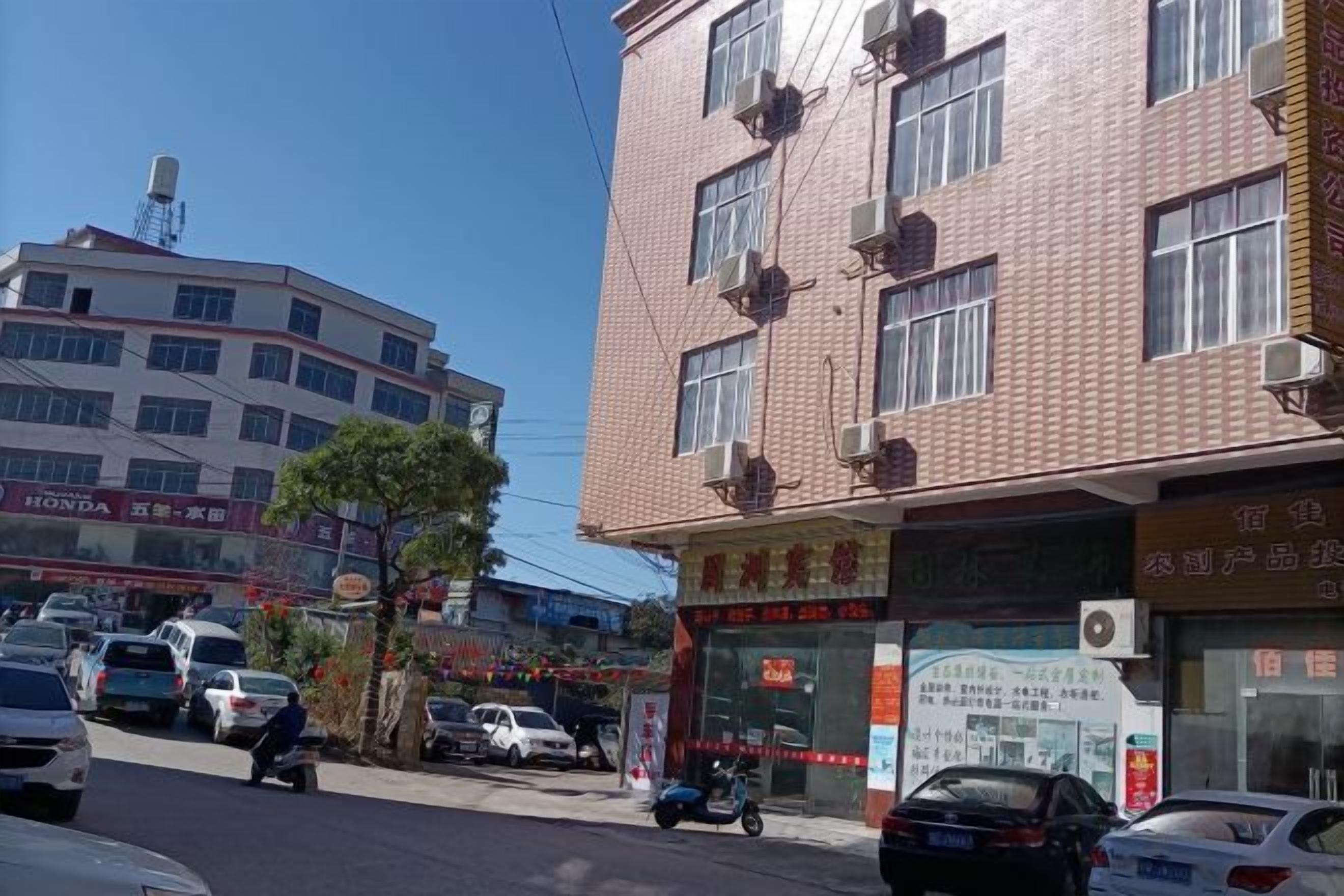 A street scene with buildings, vehicles, and a clear sky.