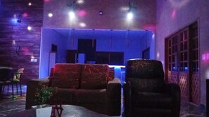 A room with a sofa, a chair, a small table, and a potted plant.