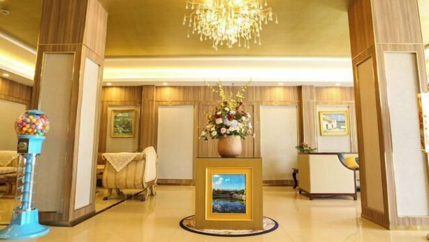 A lobby with a chandelier, a reception desk, a framed picture, and a gumball machine. - An Hengsha Isiand Resort Hotel (Shanghai)