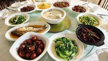 A round dining table with multiple dishes of various foods.